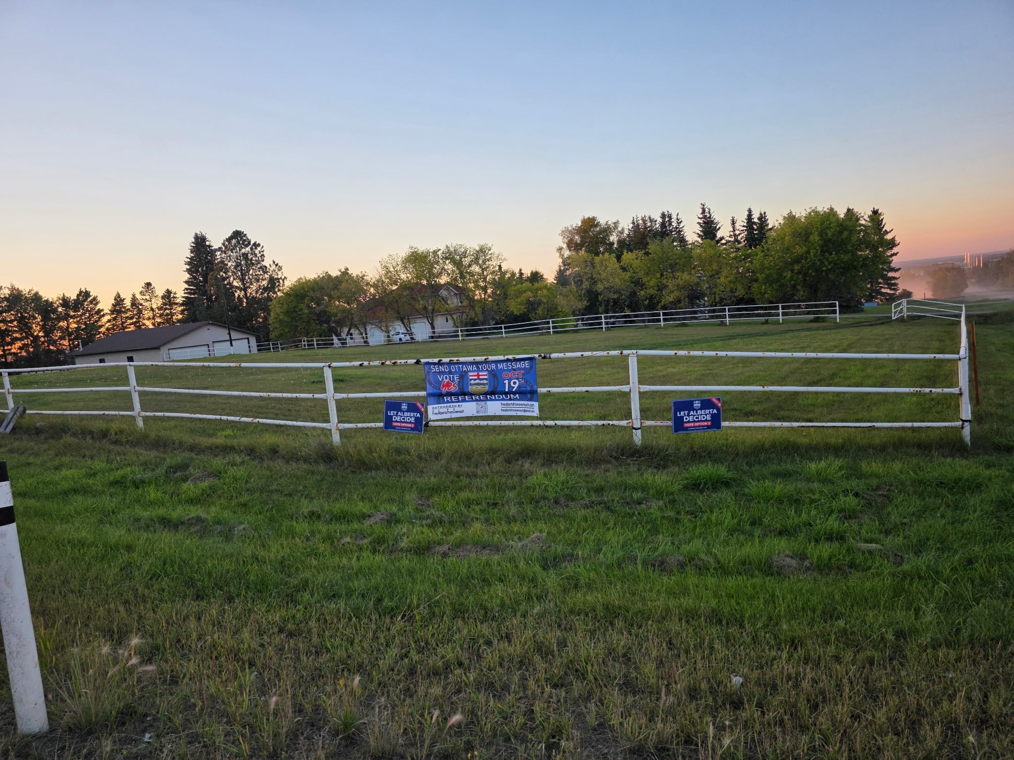 Vote Yes referendum signs on white fence at sunset