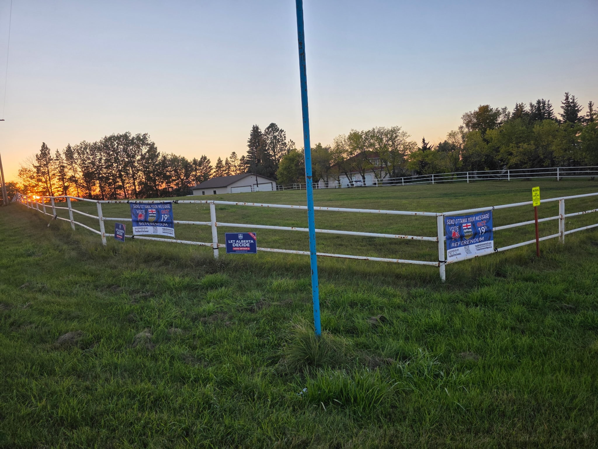 Let Alberta Decide and Send Ottawa Your Message signs on white fence at sunset