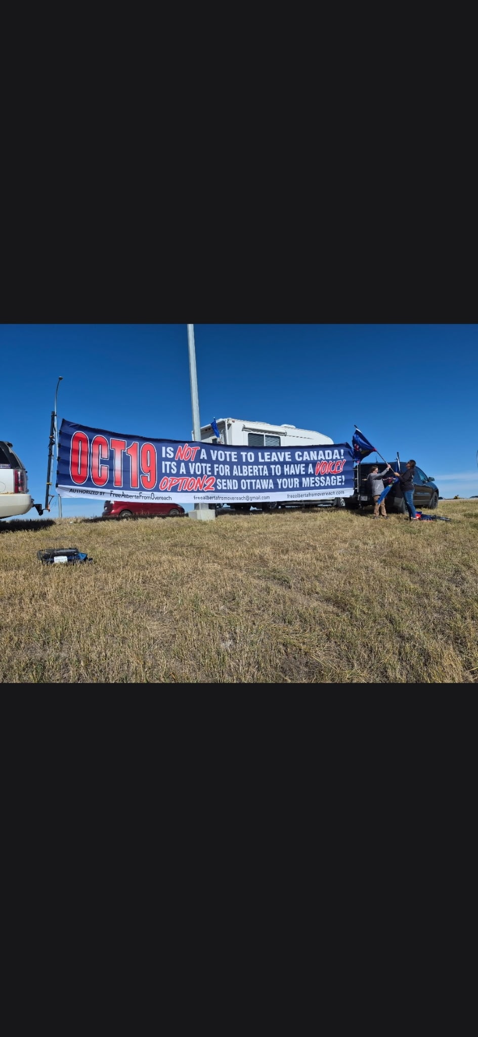 Volunteers installing Oct 19 referendum banner roadside