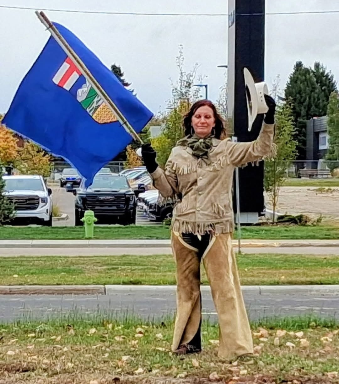 Albertan waving provincial flag in western attire