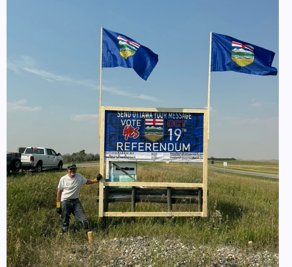 Volunteer installing Vote Yes billboard in field